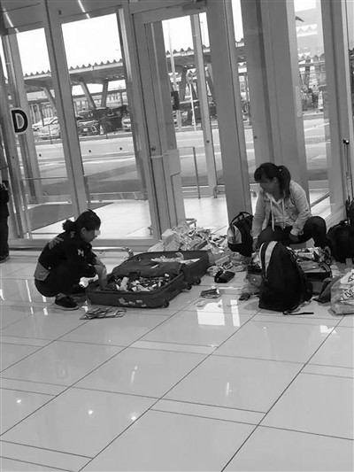 日本某机场因行李超重，两个女生不得不现场拆除所有包装。