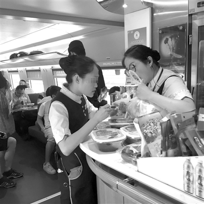 餐车乘务员交接要送的外卖。 