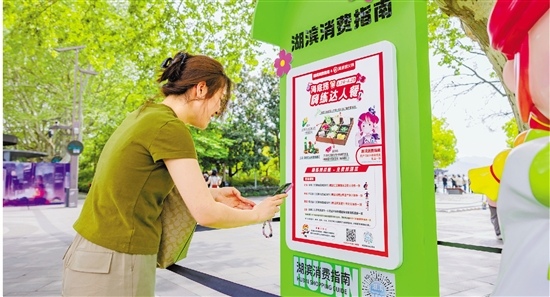 日前在杭州湖滨步行街,游客扫码进入“湖滨消费指南”。 记者 曹坚 摄