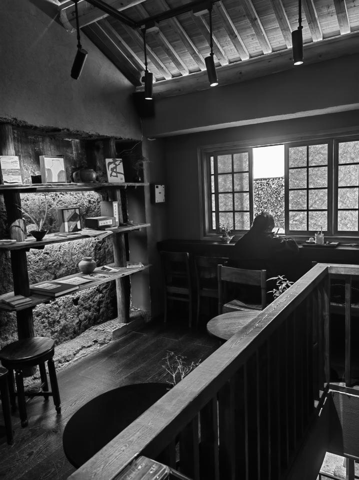 工作日午后,在质朴木石风格的半朵咖啡馆内,一位读者正在静心阅读、学习。